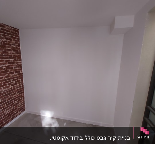 קיר גבס לבן ליד קיר לבנים אדומות